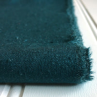 close-up of folded teal green raw silk noil
